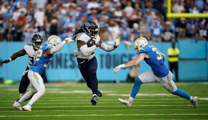 Titans running back Derrick Henry (22) gets stopped by Los Angeles Chargers linebacker Nick Niemann (31) and safety Alohi Gilman (32) in the overtime at Nissan Stadium.